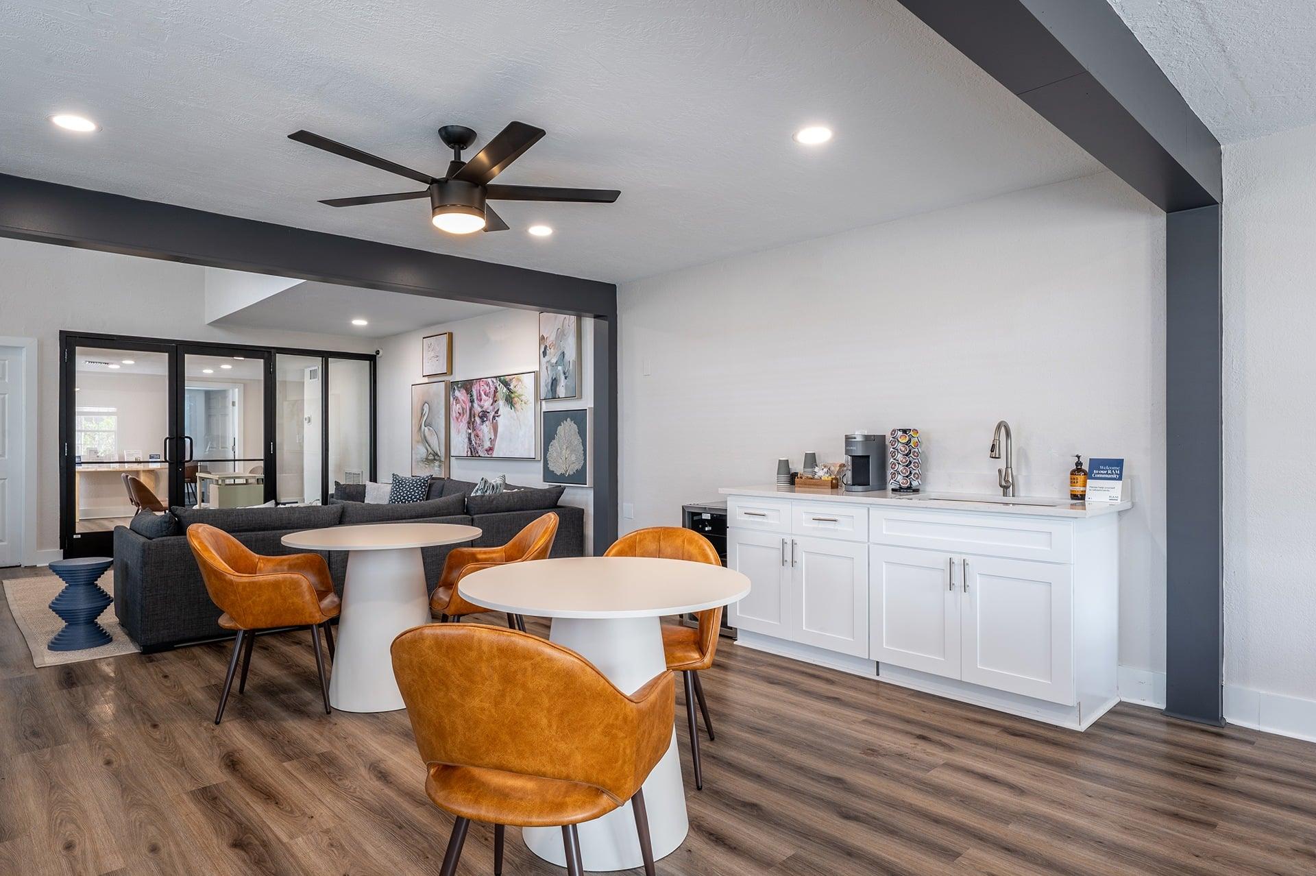 A modern dining room with a white table and orange chairs.