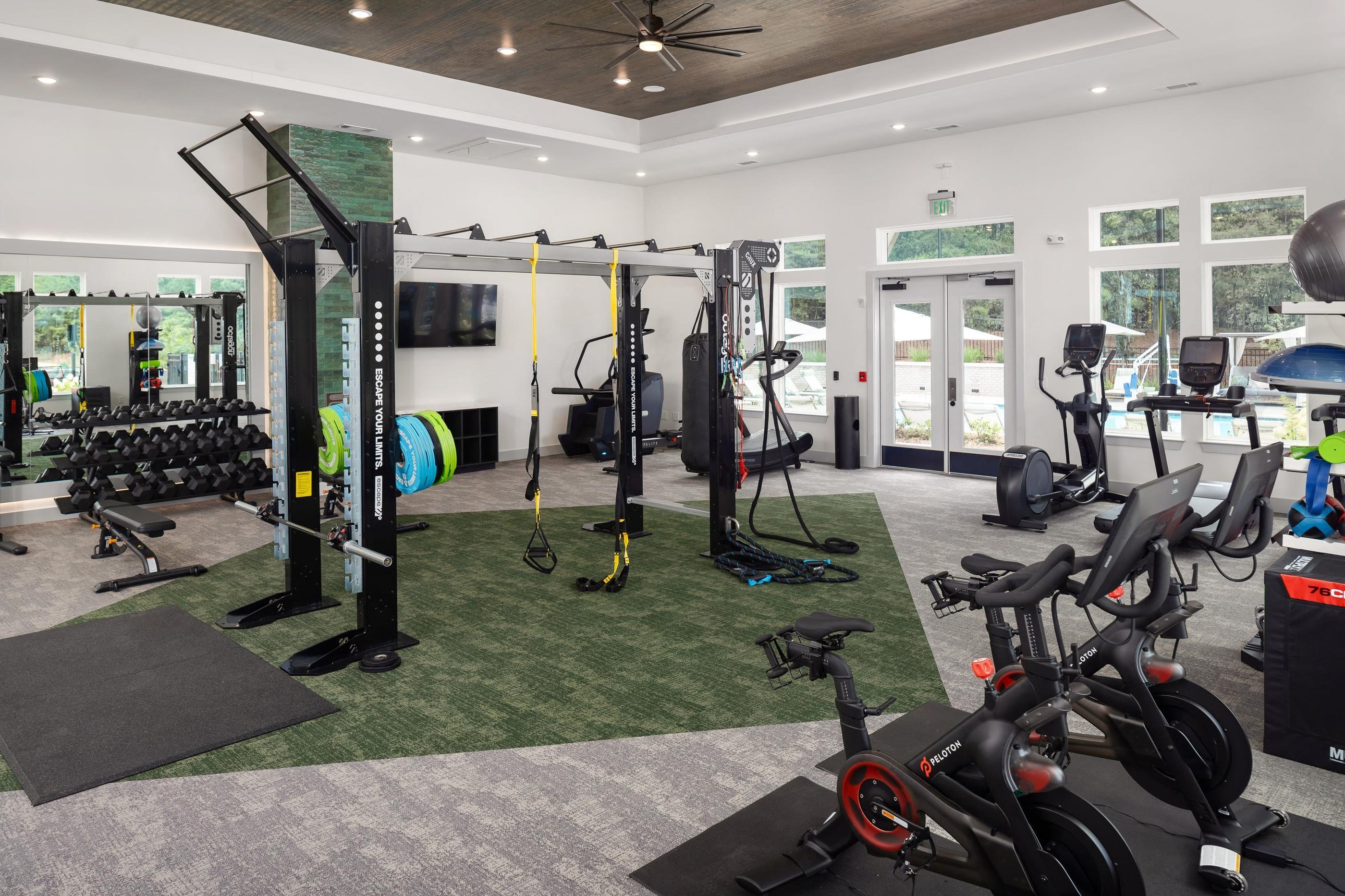 a gym with weights and other exercise equipment in a building with glass doors