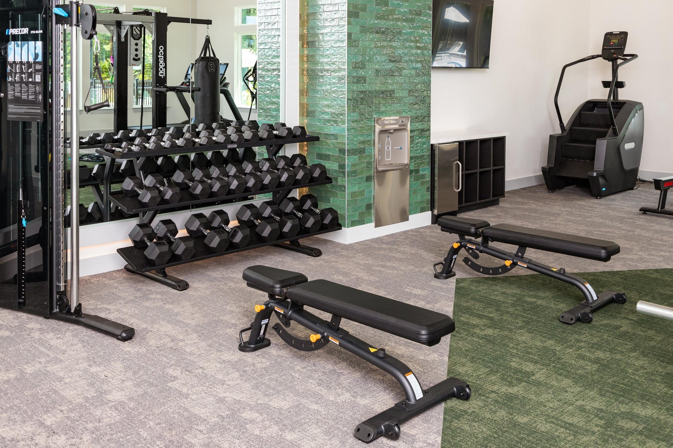 two views of a fitness room with weights and cardio equipment and a wall of mirrors