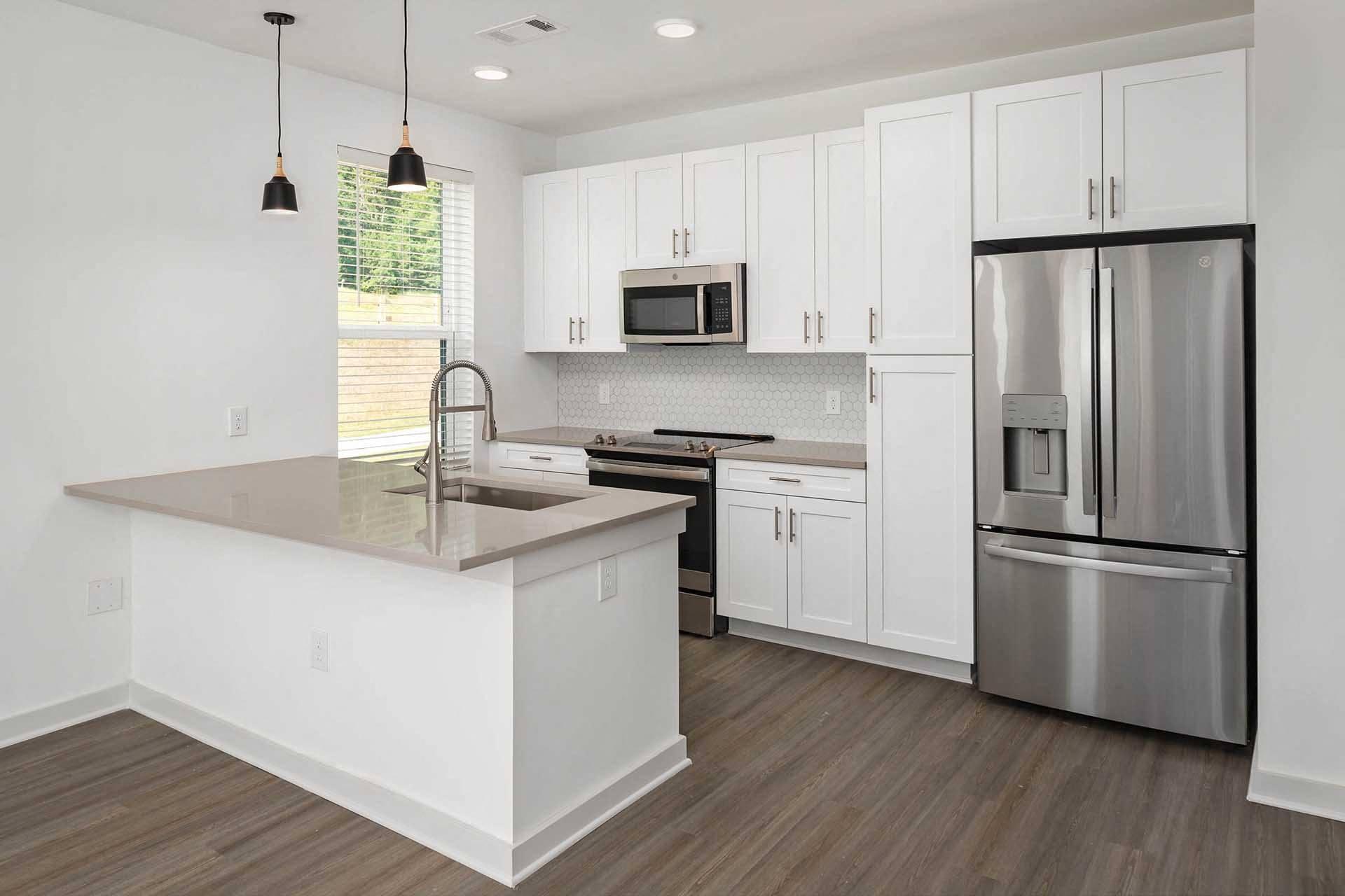 a white kitchen with stainless steel appliances and a counter top