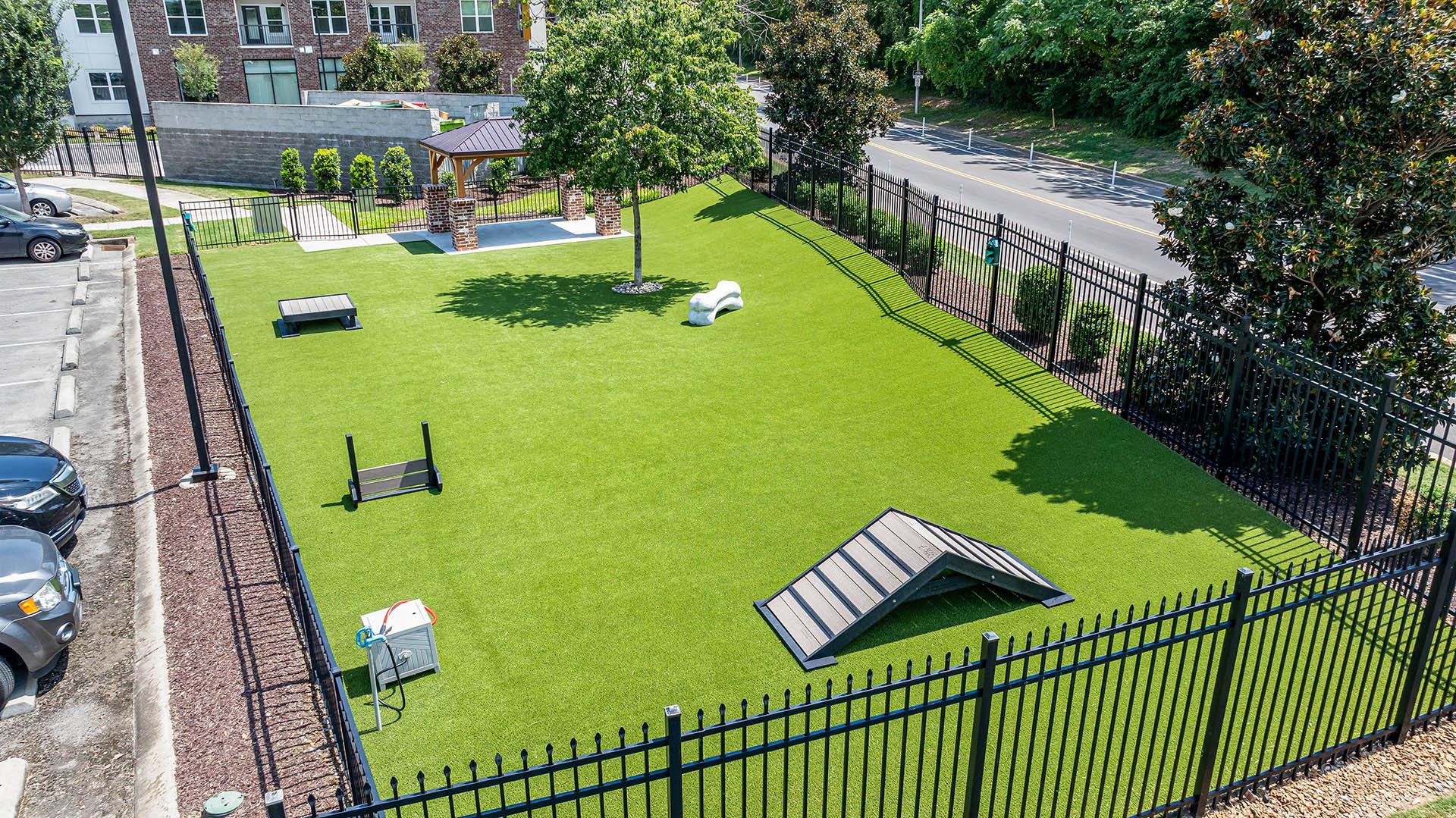 a dog park with a picnic table on the grass