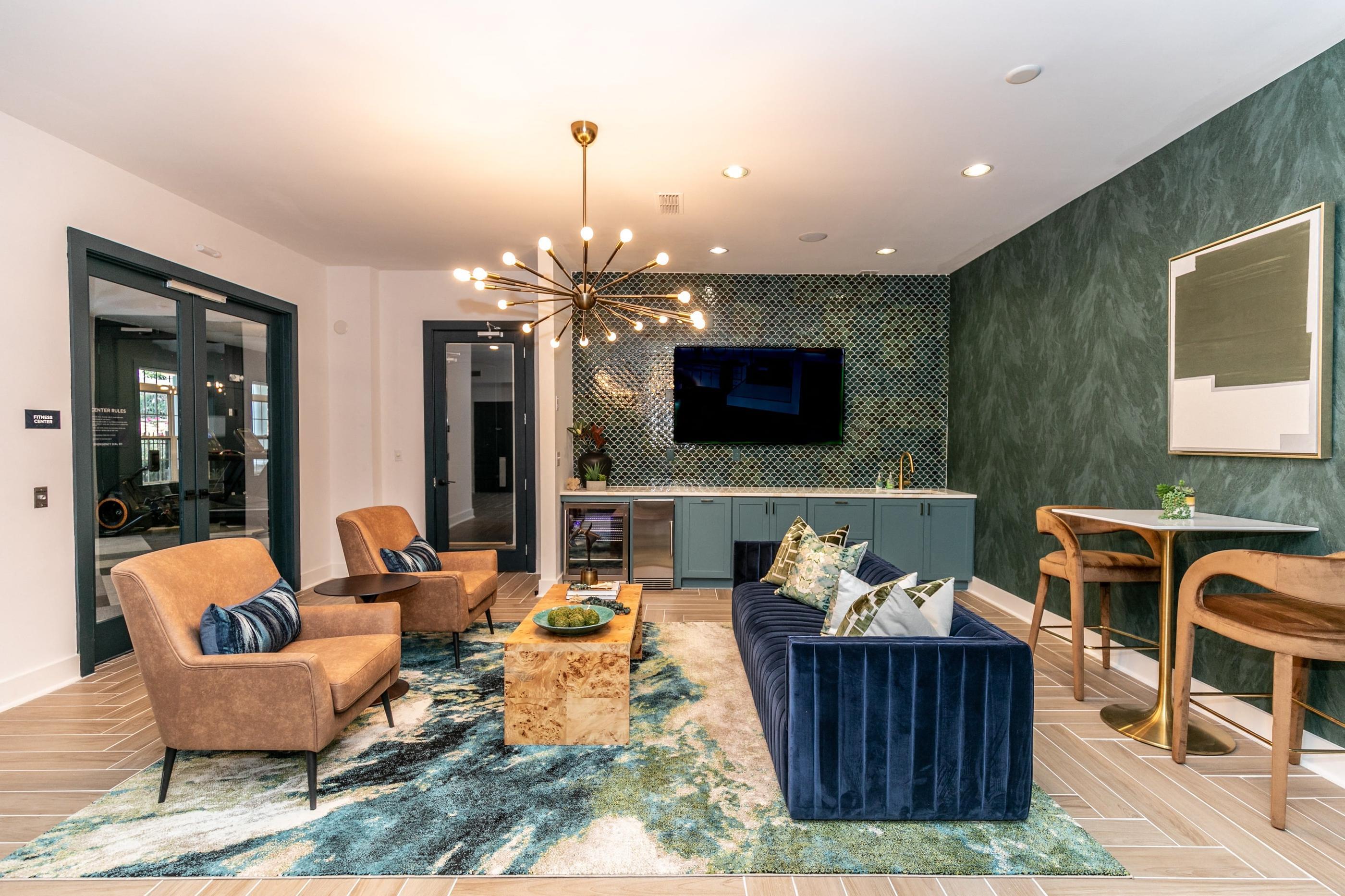 A living room with a blue rug and a chandelier.