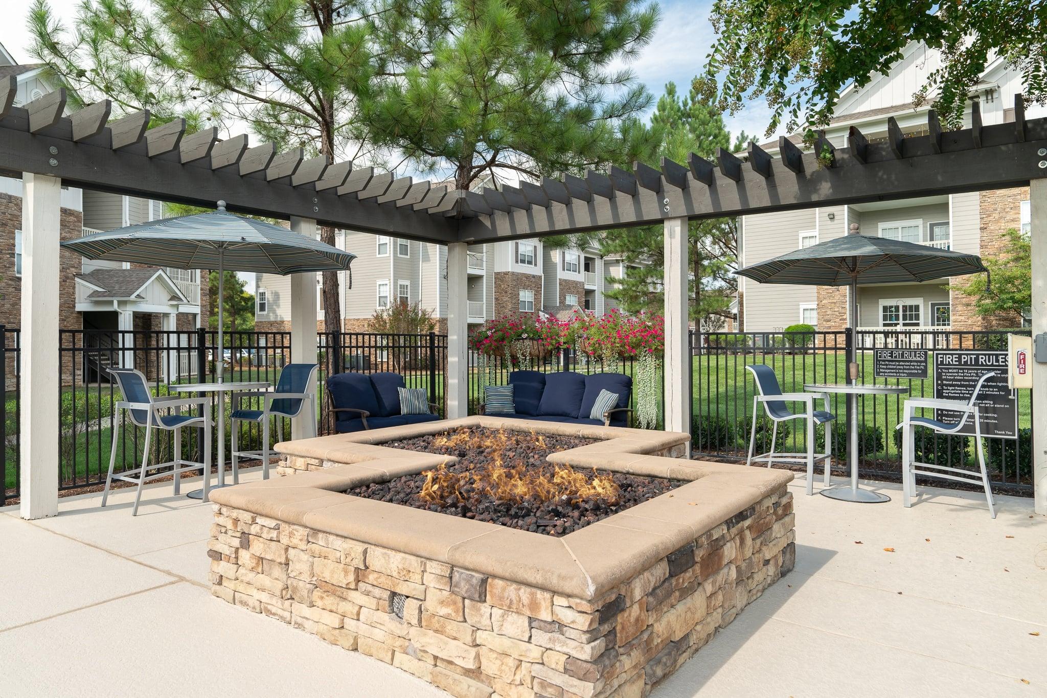 our patio has a fire pit and tables with chairs and umbrellas