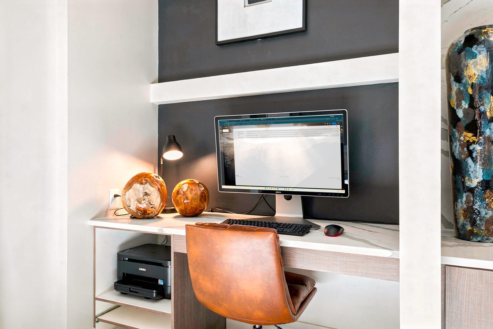 A computer desk with a monitor, keyboard, and mouse.