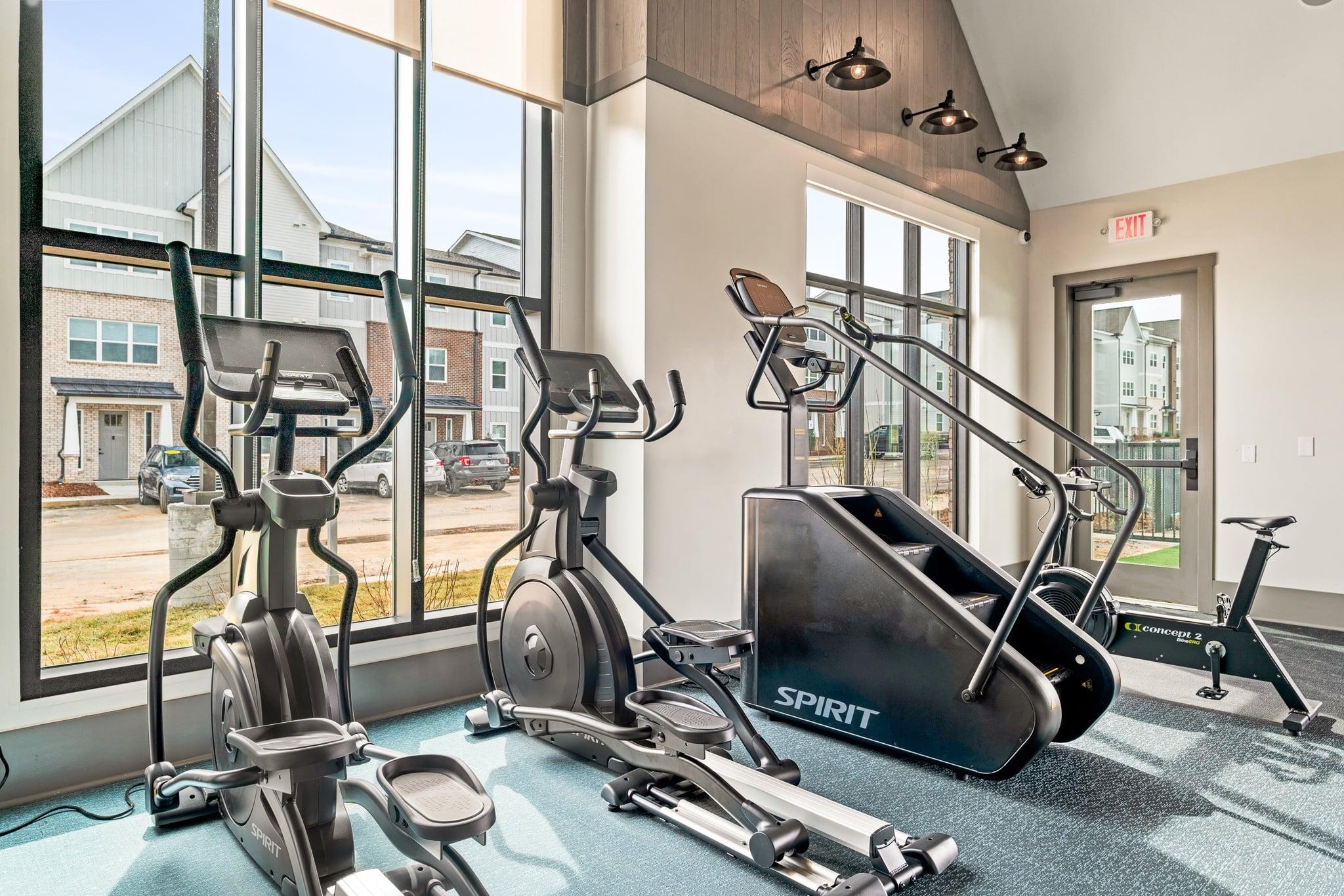 A gym with a row of exercise bikes and a treadmill.