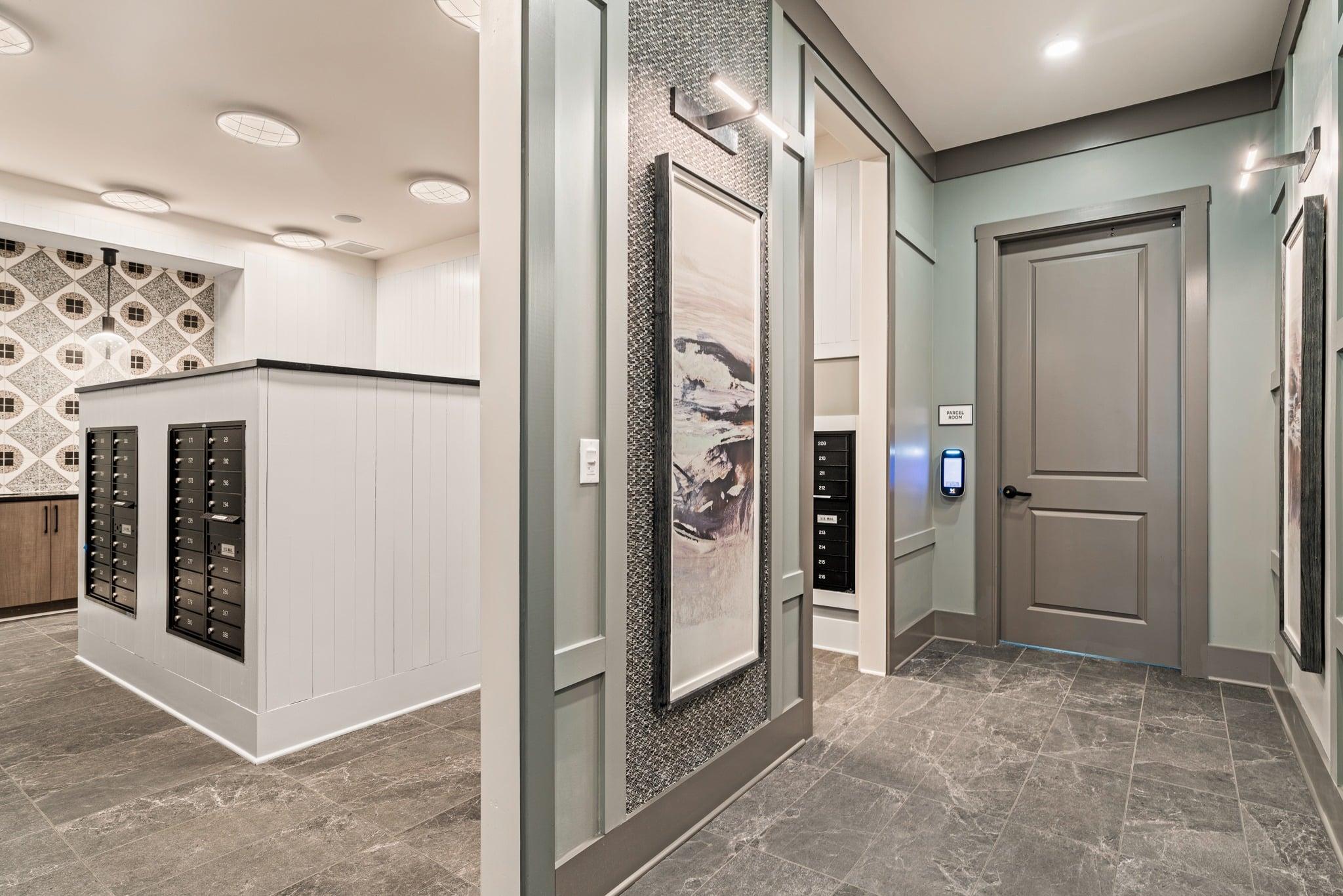 A hallway with a grey floor and a white wall with a black and white pattern.