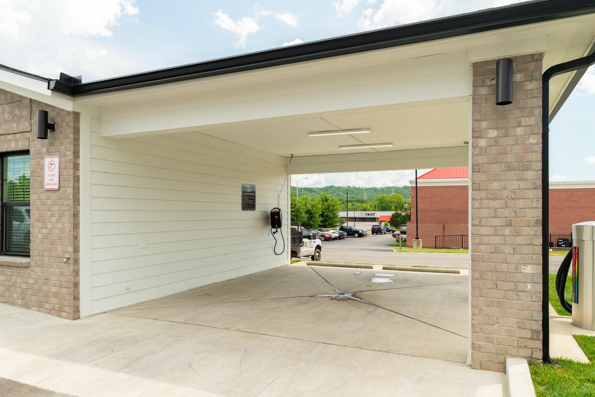 A parking garage with a brick pillar and a white wall.