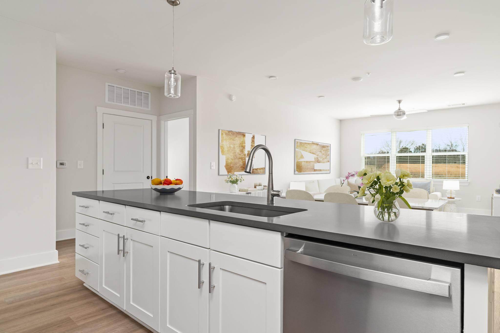 A modern kitchen with white cabinets and a black countertop.