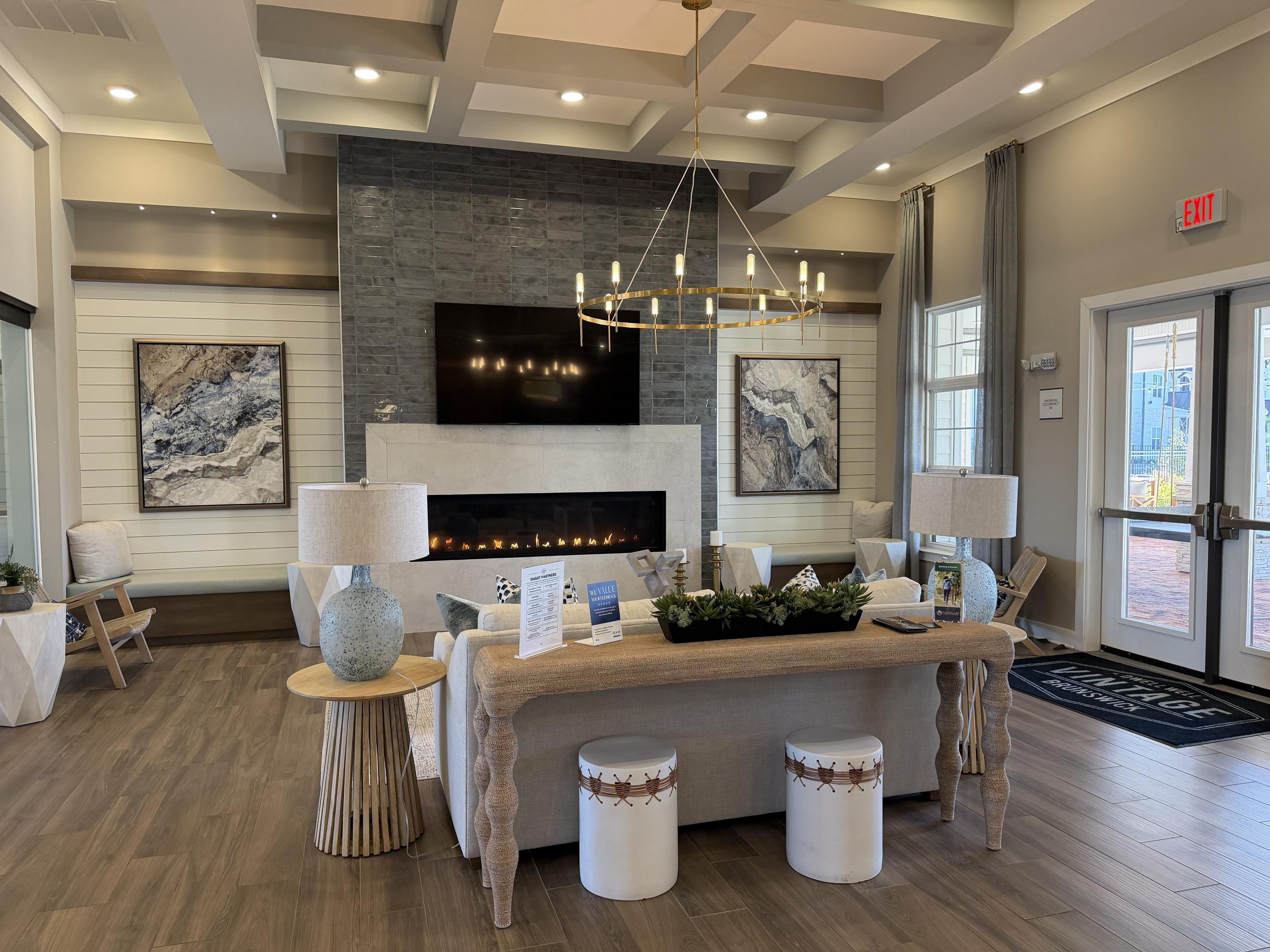 A modern living room with a fireplace and a long table.
