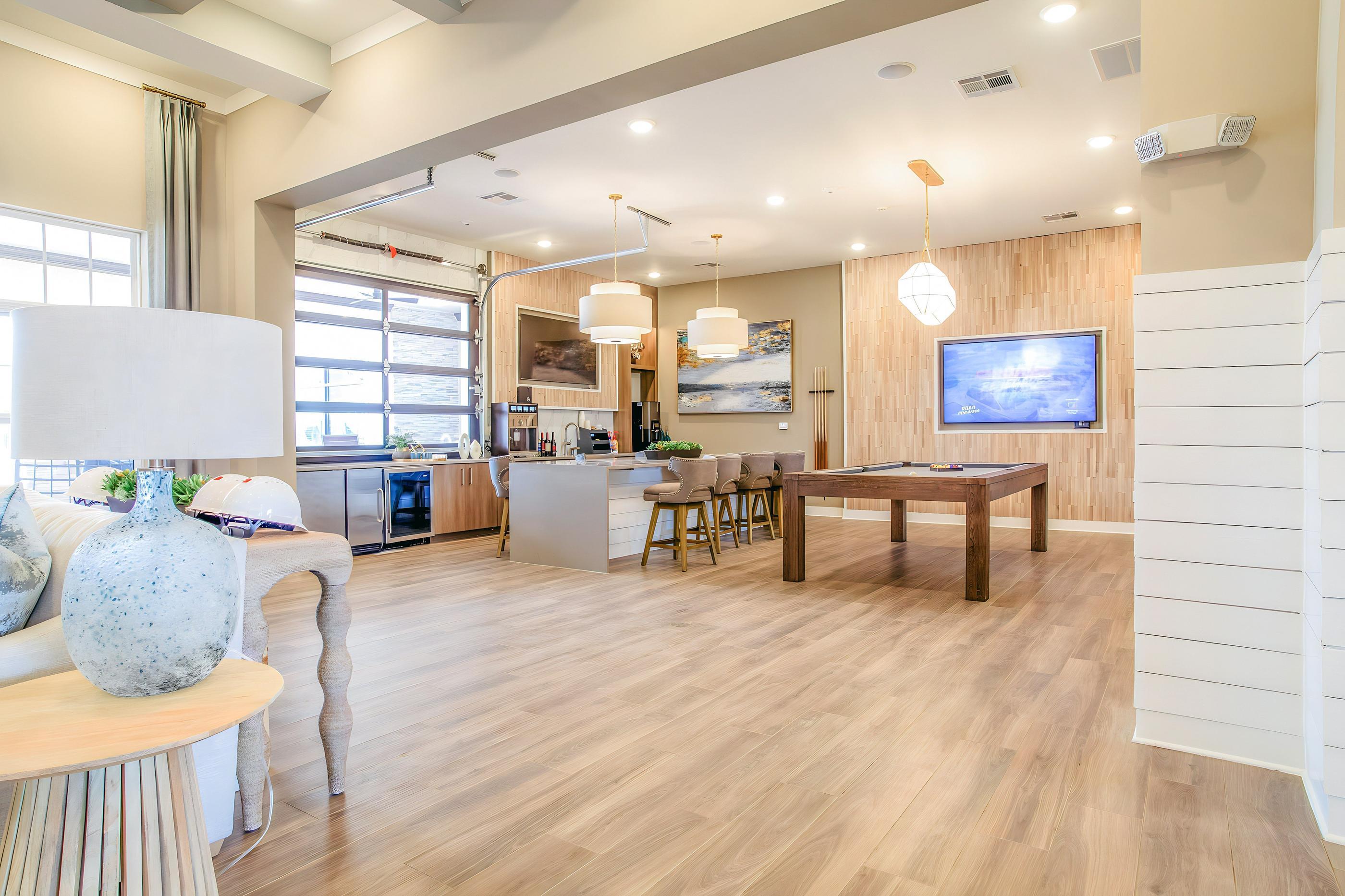 A modern living room with a wooden floor and a television on the wall.