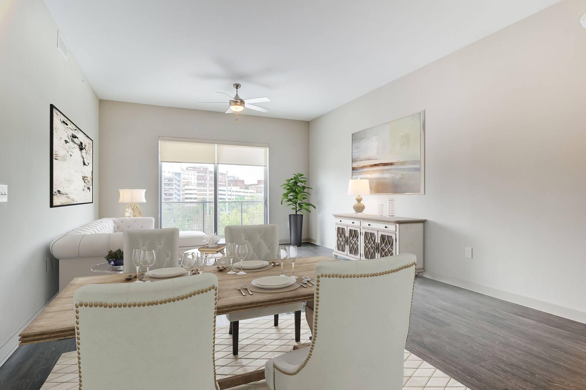 A dining room with a table set for two and a ceiling fan.