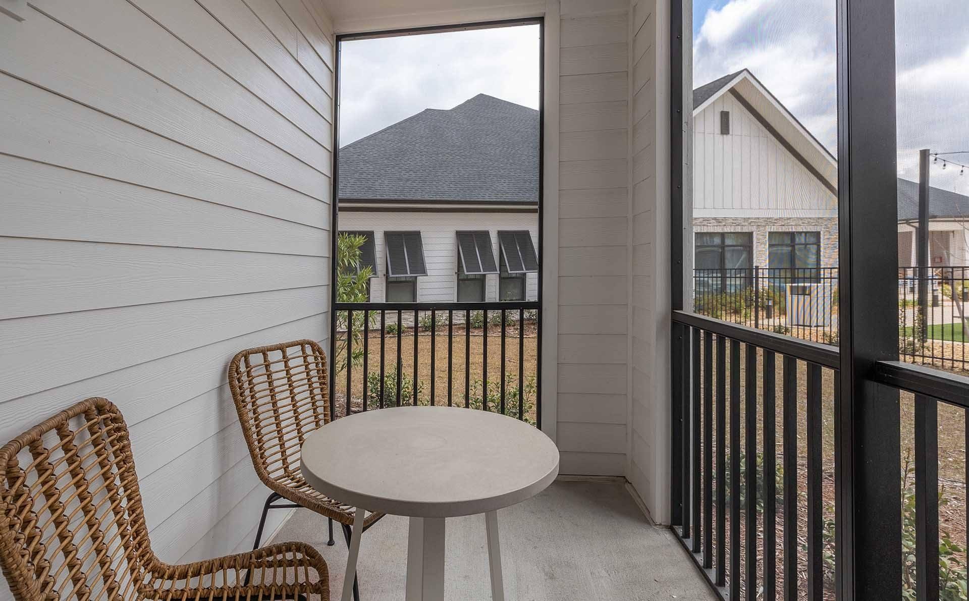 A balcony with a round table and two chairs.