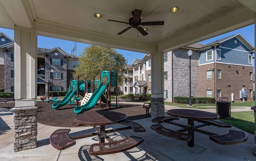 Covered patio with tables and chairs and playground equipment