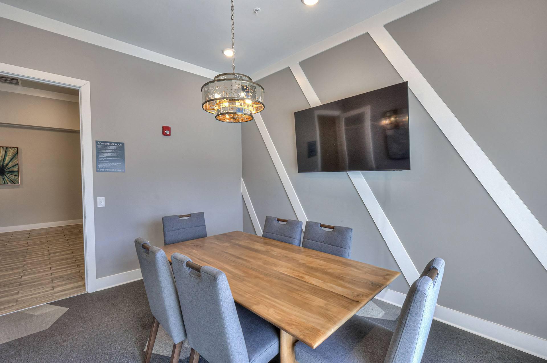 A dining room with a wooden table and grey chairs.