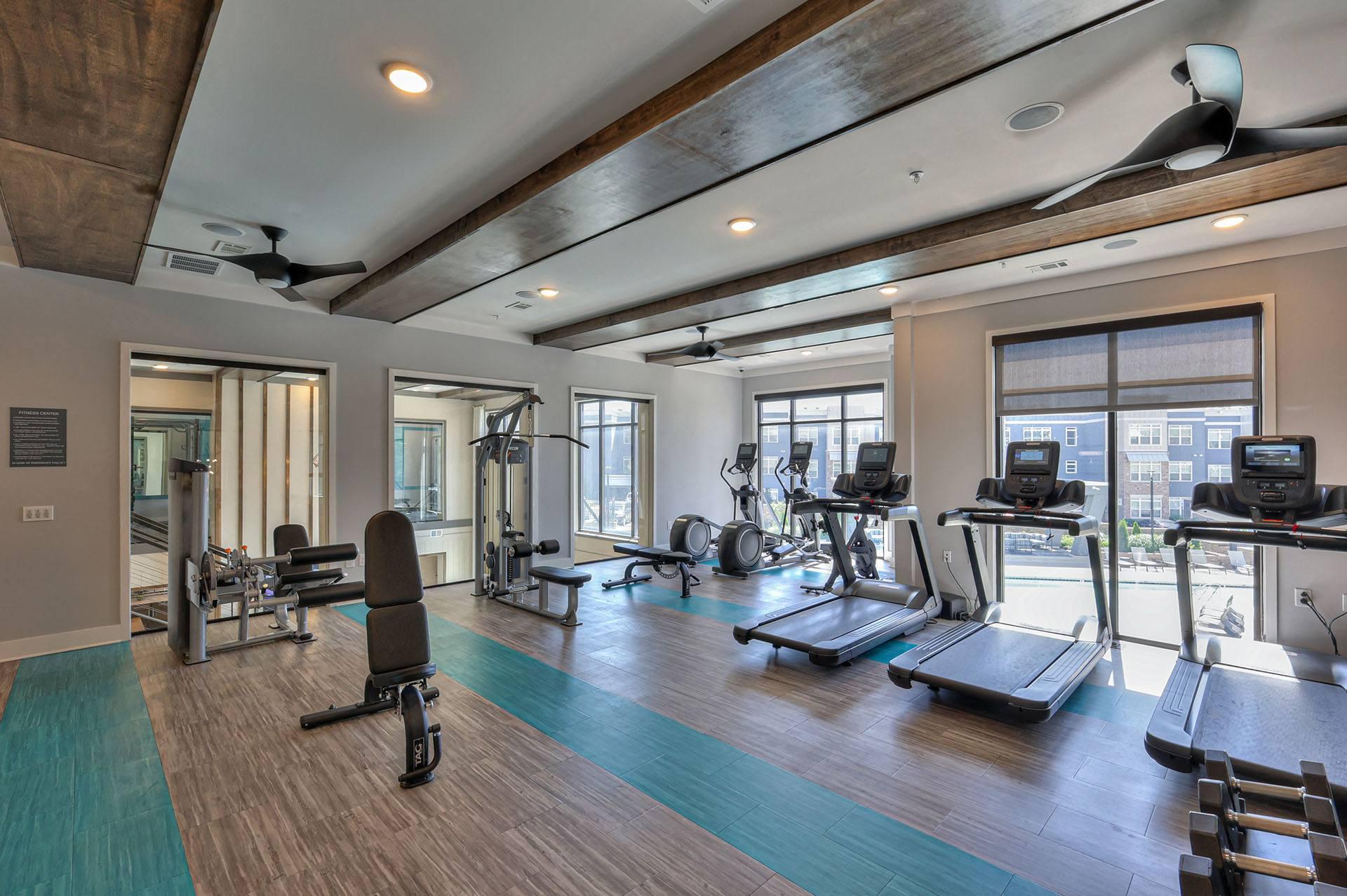 A gym with treadmills, weights, and exercise equipment.