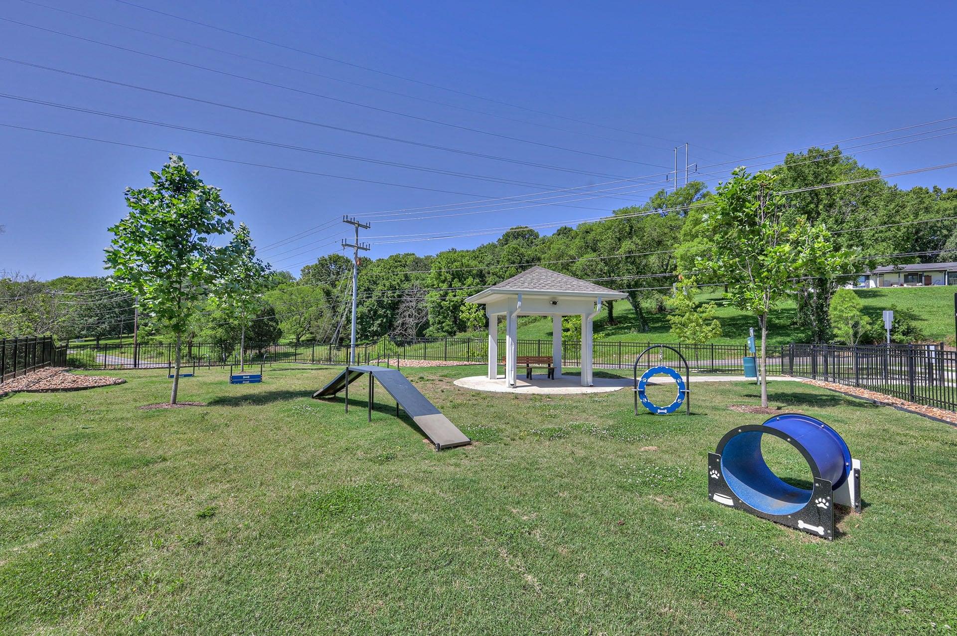 A playground with a slide, swings, and a seesaw.