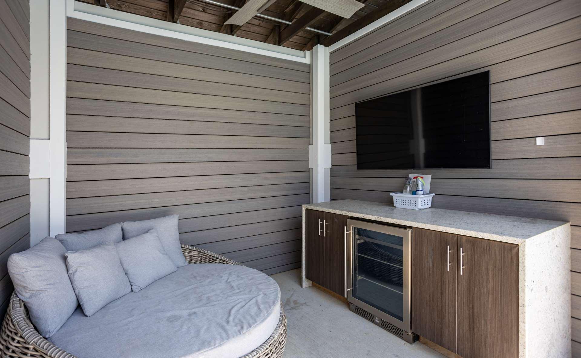 A cabana with a chair, a cabinet, and a TV.