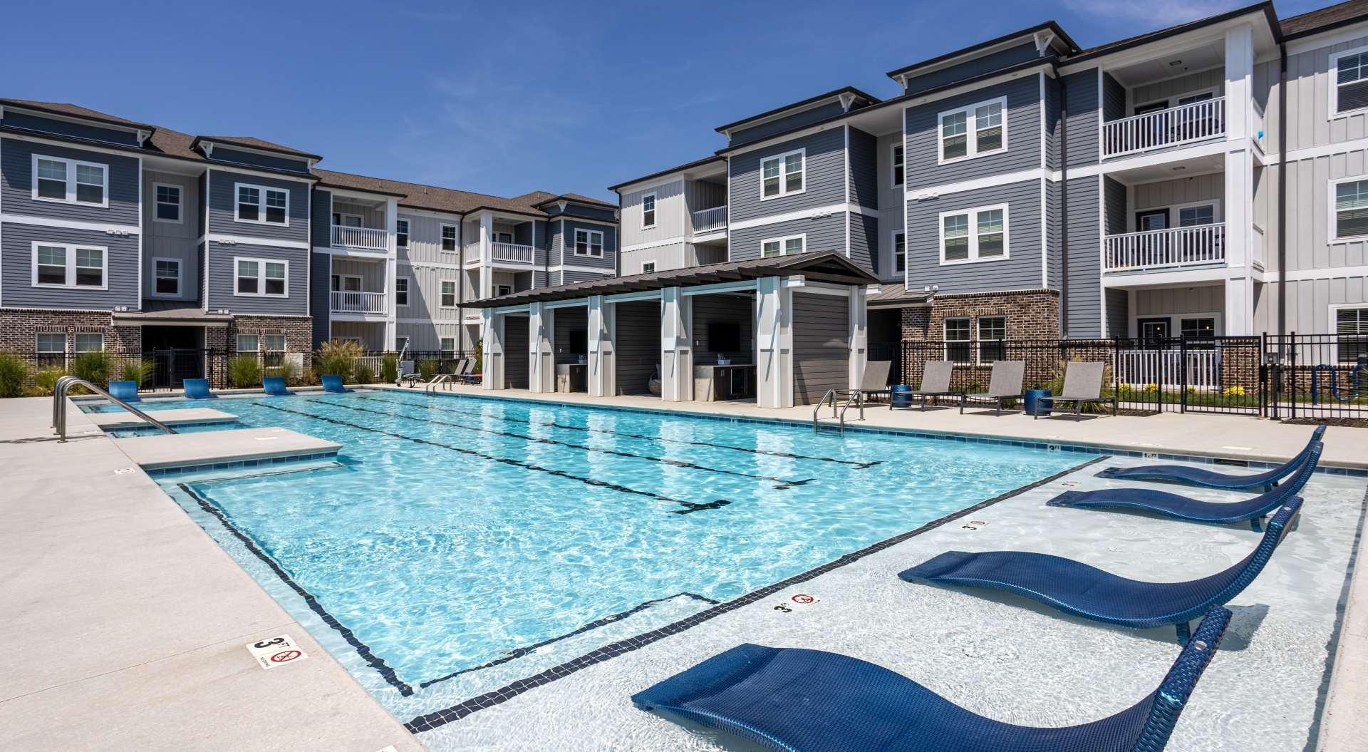 A large swimming pool in front of apartment buildings.