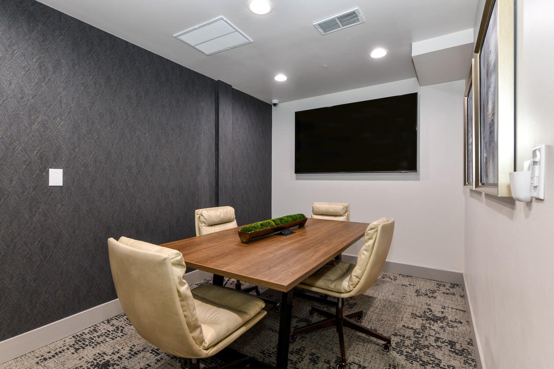 a meeting room with a table and chairs