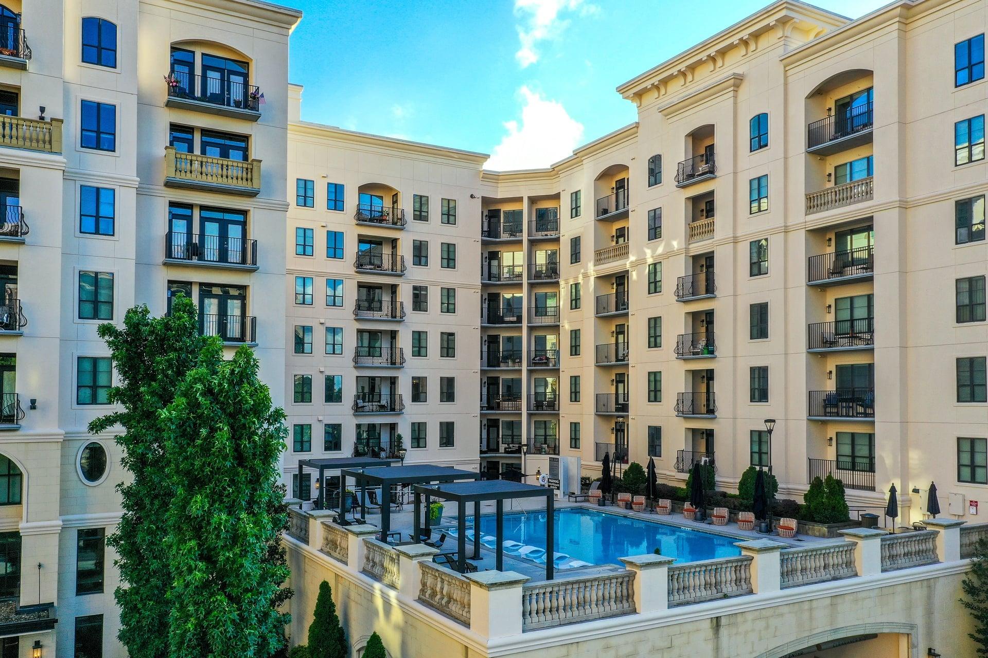 a large swimming pool in front of an apartment building