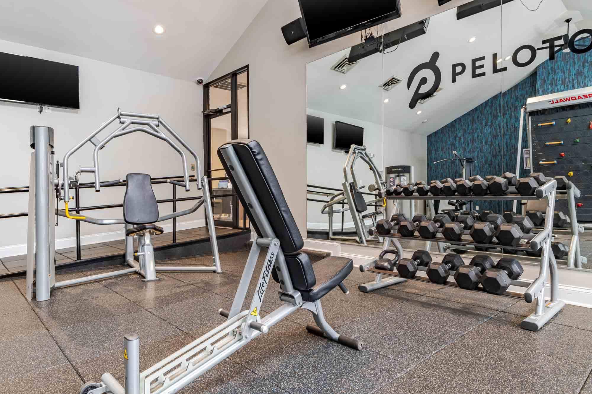A gym with a Peloton logo on the wall.