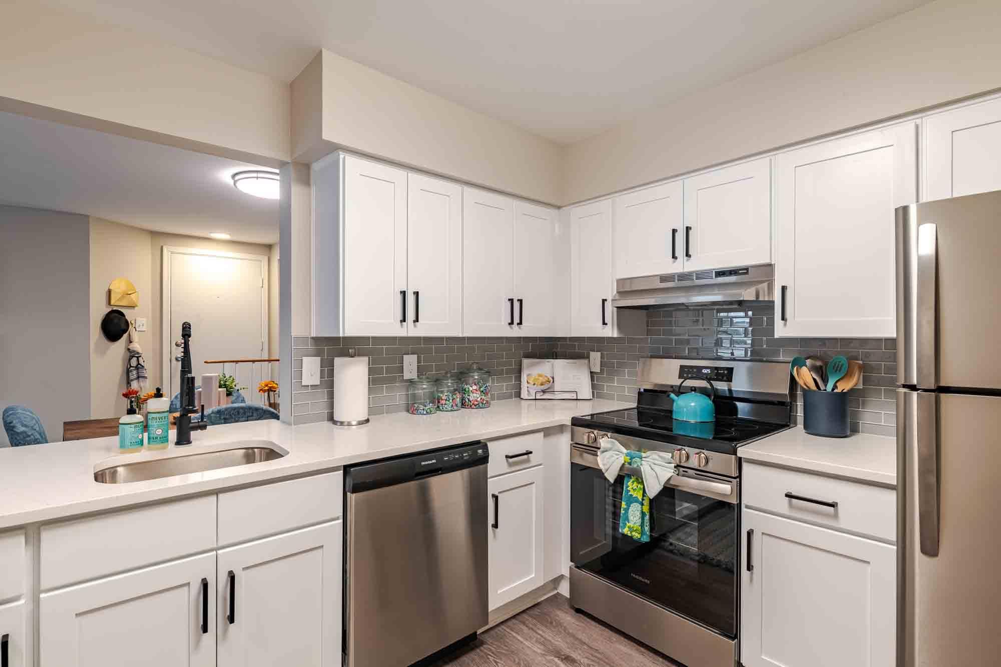 A kitchen with white cabinets and stainless steel appliances.