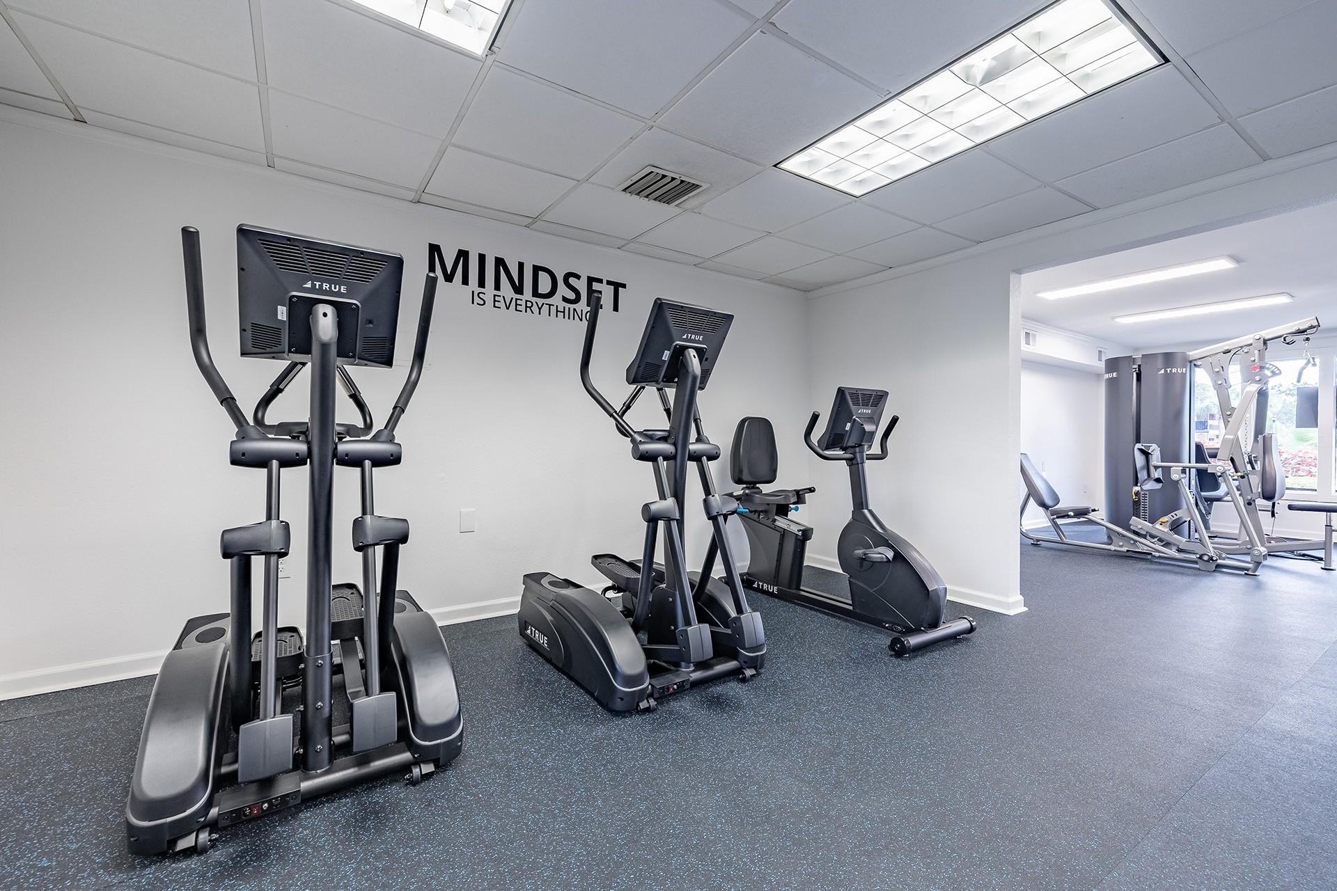 A gym with a row of treadmills and elliptical machines  at Waterview at Rocky Point, Tampa