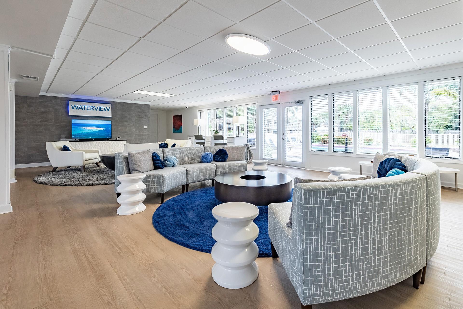 A living room with a blue rug and white furniture  at Waterview at Rocky Point, Tampa